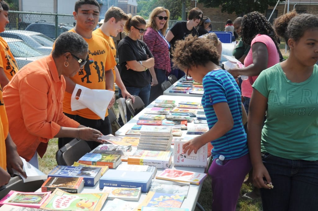 Laneta Goings, far left, gives out free books to children. Books 4 Buddies has donated more than 30,000 books to promote literacy in Ohio as well as places like Belize.