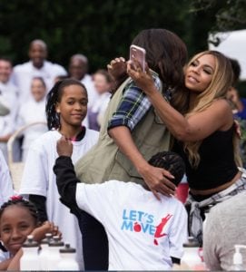 First Lady Michelle Obama hugs school kids and Grammy Award-winning singer Ashanti. (Photo: Cheriss May/HUNS)